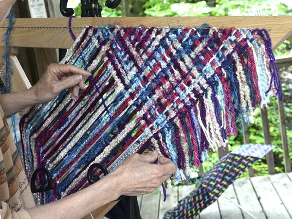 IHEA student creating a shawl on a triangle loom