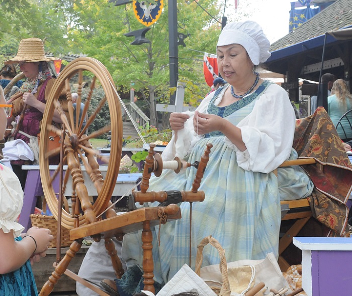 IHEA spinner demonstrating using a spinning wheel at the Kansas City Renaissance Festival