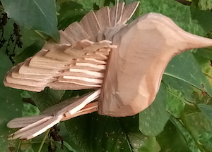 A close up of a wood fan bird created using the riving technique